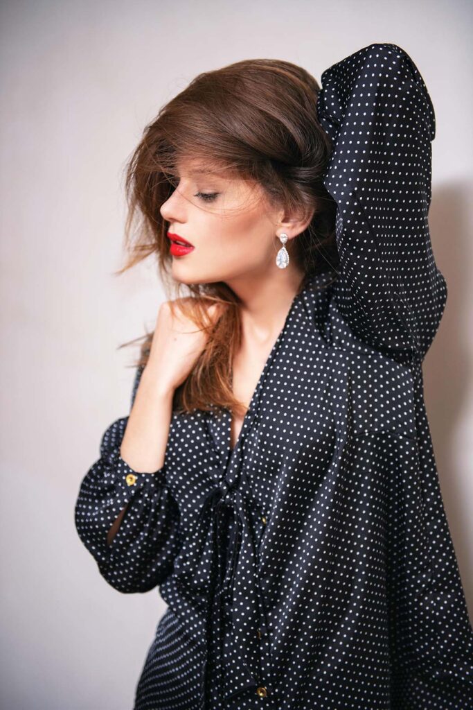 elegante blusa negra con patron de puntitos negros, vestuario para la mujer ejecutiva